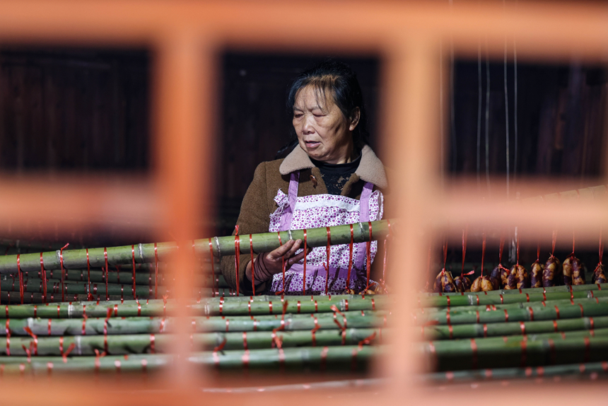 村民在熏制腊味。