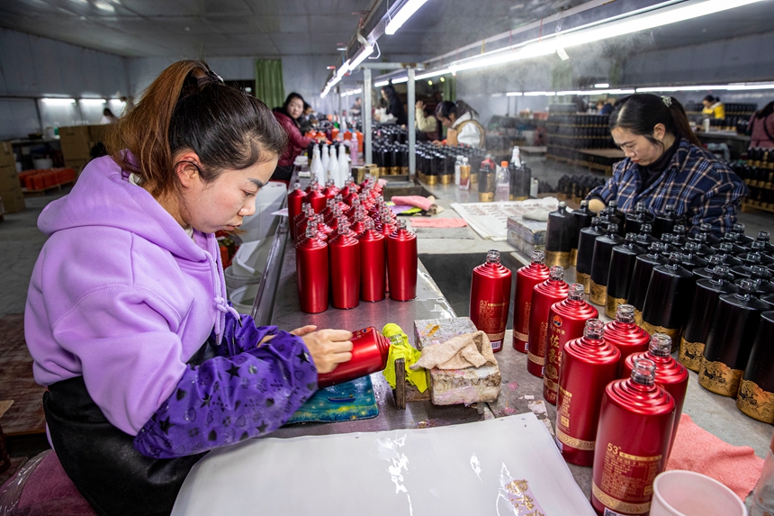 2025年12月17日，工人在貴州省金沙縣經濟開發區一家白酒包裝企業車間生產線上作業。