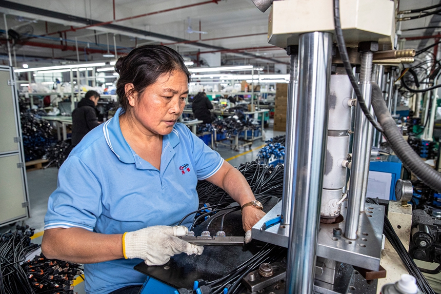 2025年12月17日，工人在貴州省金沙縣經濟開發區一家數據線生產企業車間生產線上作業。