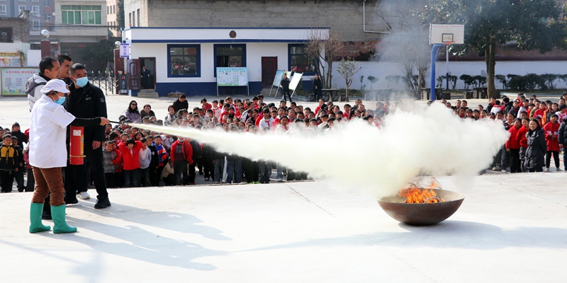 食堂工人在体验使用灭火器。
