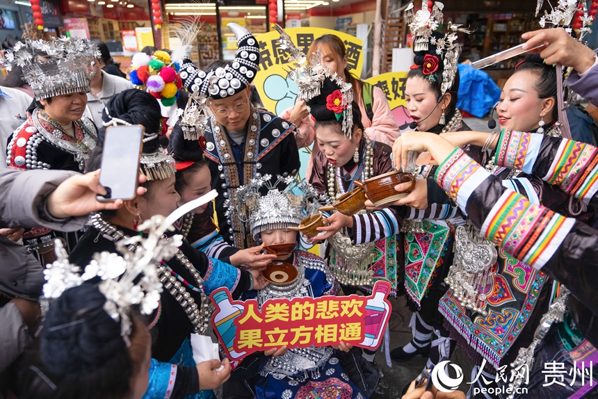 12月20日,游客在肇兴侗寨体验当地民俗。人民网记者 涂敏摄
