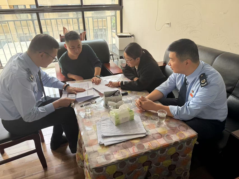 平塘县税务局工作人员向纳税人讲解银税互动宣传手册.jpg