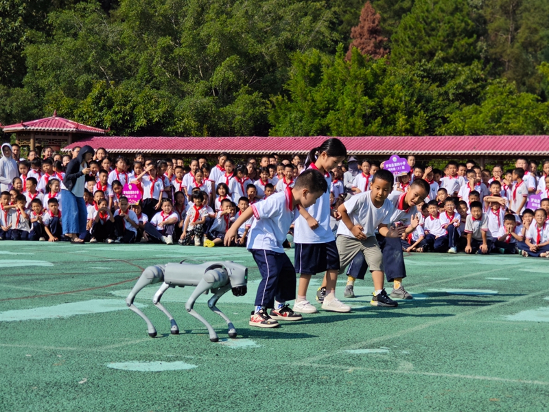 罗甸：人工智能进校园 ，点亮少年科技梦。图为学生与机器狗赛跑。 秦正苏、陈由醒供图.jpg