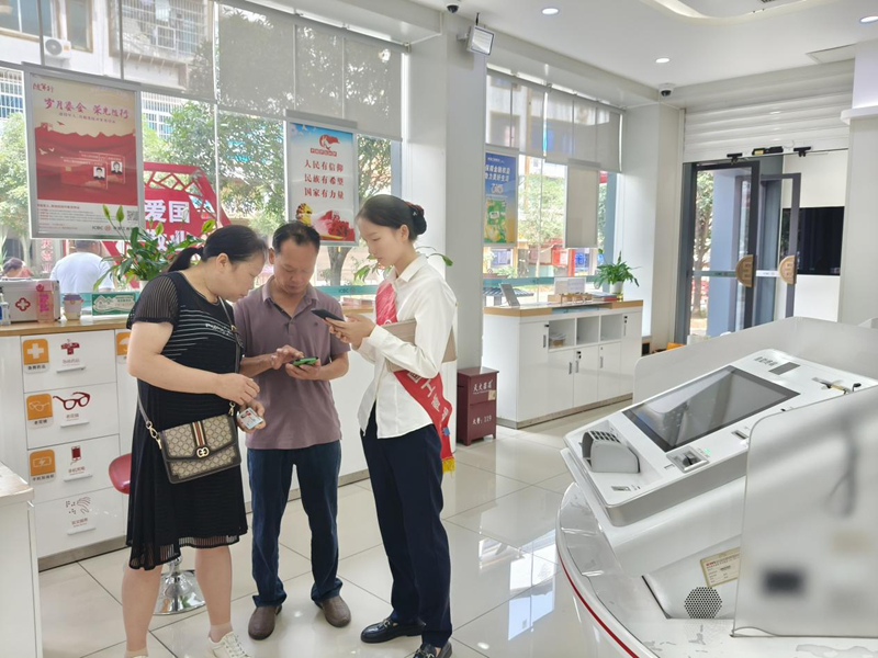 施秉县一银行工作人员正在为市民查询相关业务。