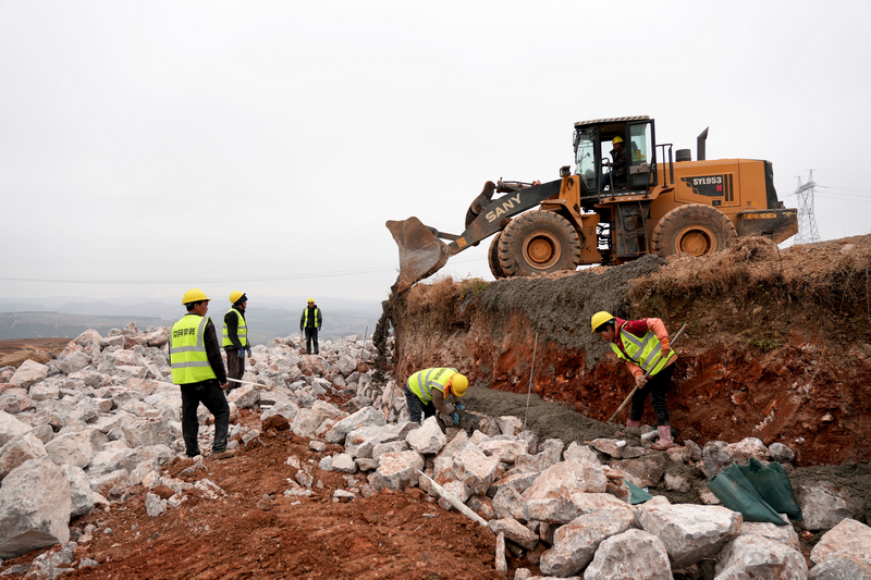 12月24日，在威寧自治縣2025年高標准農田建設項目迤那鎮櫻桃村項目區，人機協同作業，緊張砌筑田坎。陳逍攝