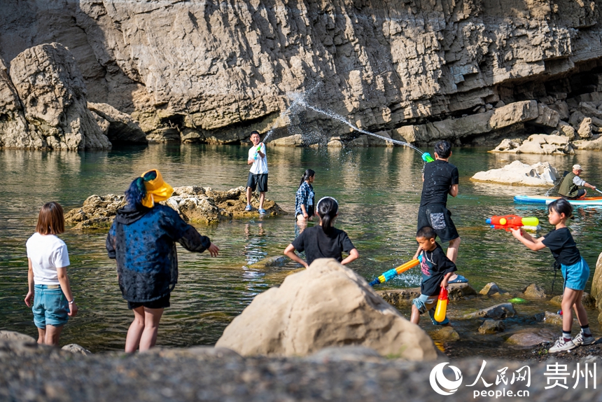 5 2025年5月2日，“五一”節期間，游客在貴州省安順市普定縣貓洞村三岔河的淺灘處在戲水嬉戲。人民網記者 涂敏 攝