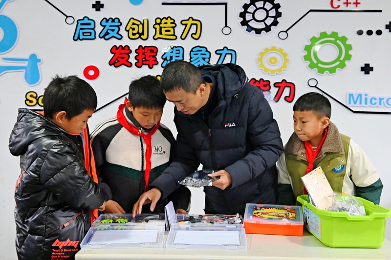 1、余磊向孩子介绍科技套装。（杨豪 摄）