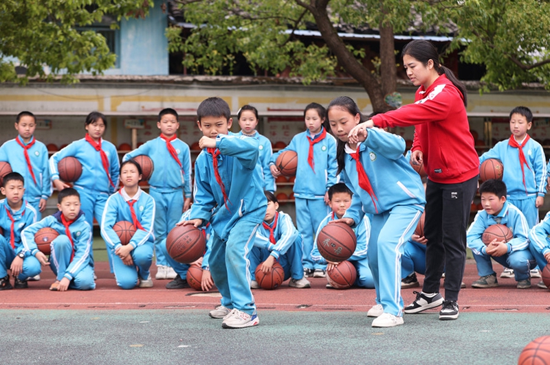 学生在老师的指导下练习运球。