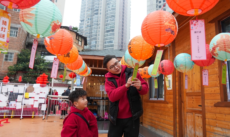 2025年12月31日，貴州省畢節市納雍縣廣黔同心幼兒園“童趣廟會”現場，家長和小朋友一起猜燈迷。 楊英 攝