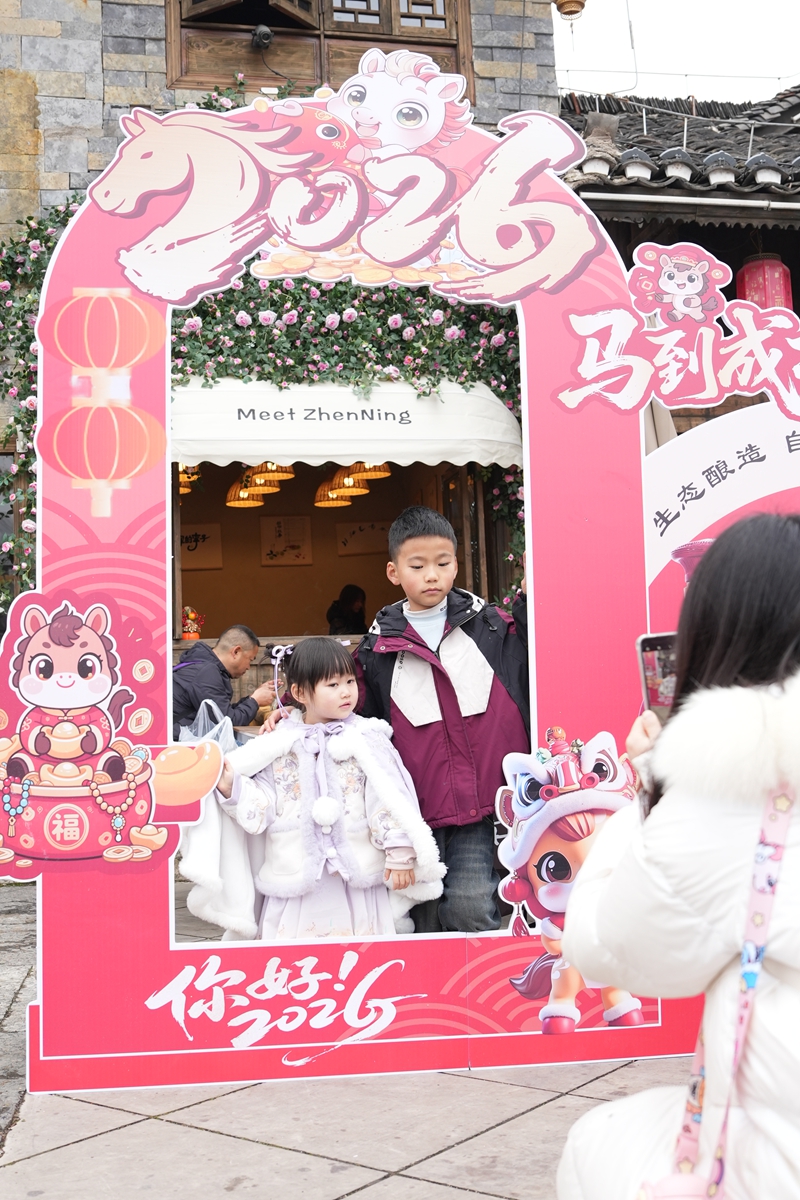 游客在鎮寧故事店前打卡。