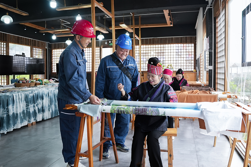 凱裡施秉供電局供電員在與公司繡娘了解用電情況。