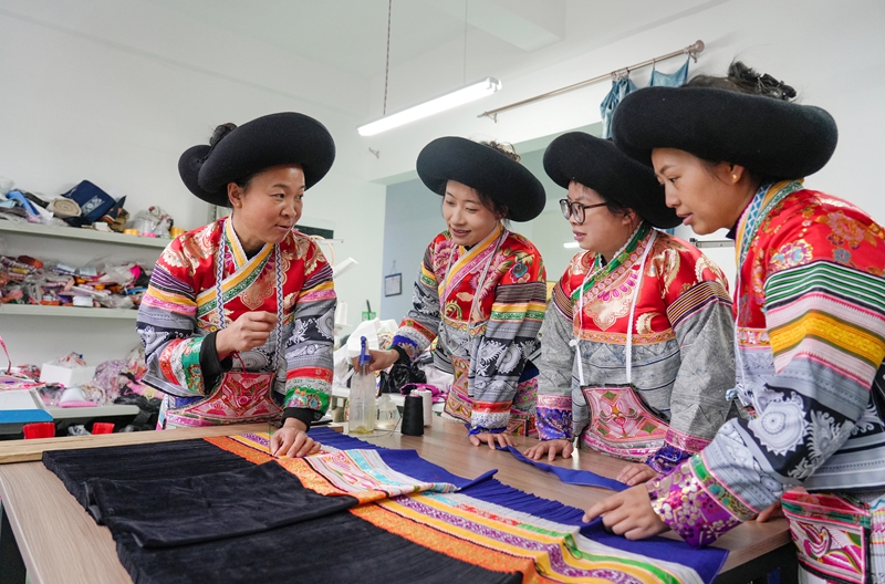 2026年1月5日,贵州省毕节市纳雍县猪场乡富纳蜡染刺绣农民专业合作社,绣娘在裙褶缝制技巧。杨英摄