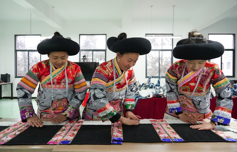 2026年1月5日,贵州省毕节市纳雍县猪场乡富纳蜡染刺绣农民专业合作社,绣娘在整理裙褶。 杨英摄