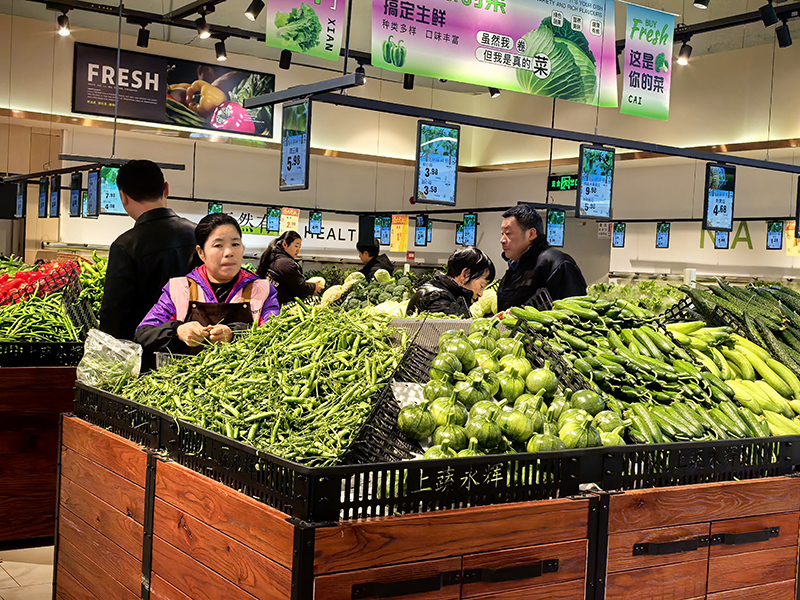 桐梓縣上蔬永輝超市，生鮮區的蔬菜貨架上，蔬菜整齊碼放，色澤鮮亮、價格親民，吸引不少市民駐足挑選。