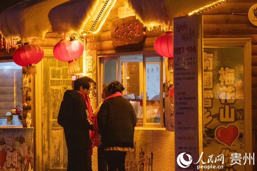 游客在“南国雪乡”品尝贵州特色美食“炸洋芋粑”。人民网 黄小桃摄