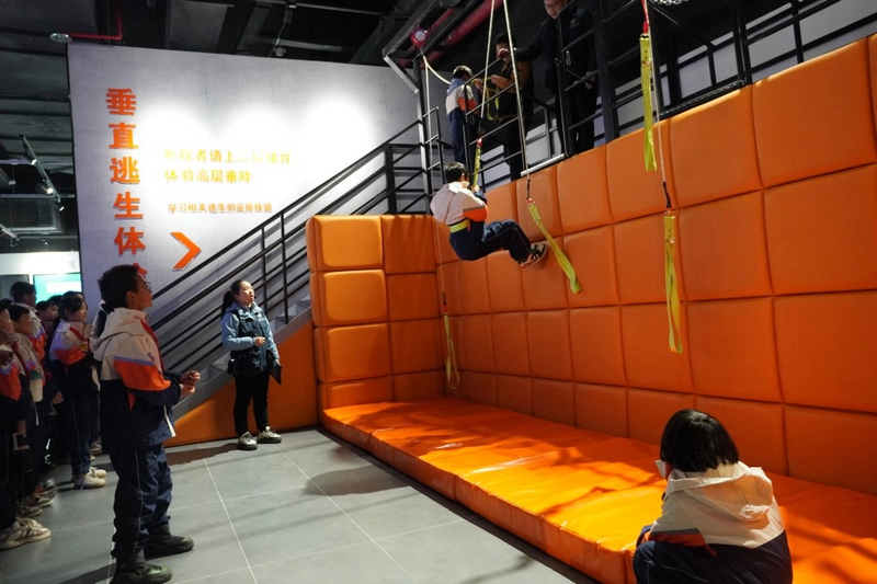 同学们排队进行垂直逃生体验,学习相关逃生技巧。