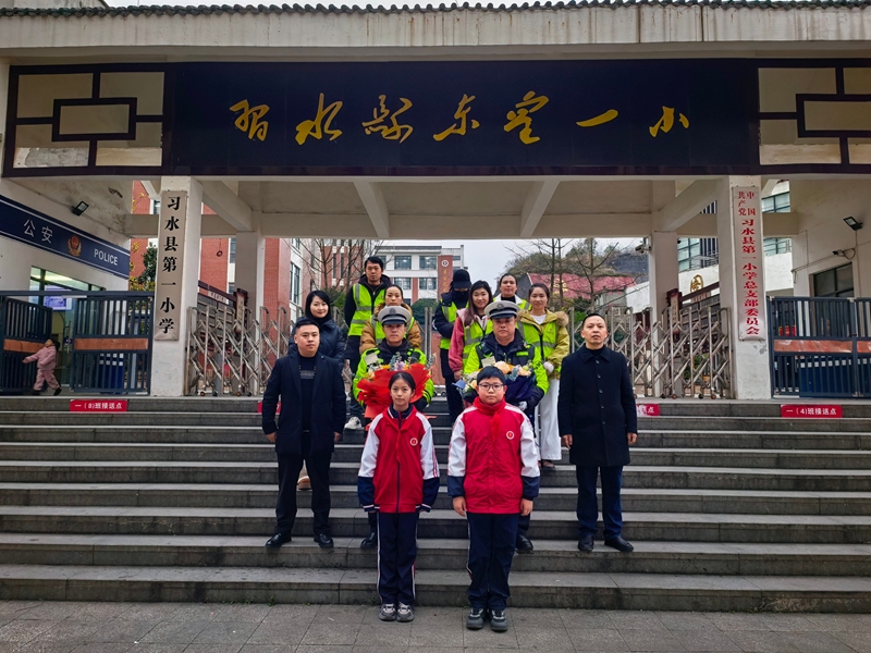 习水一小门前，少先队员向交警献花致敬，暖冬送温情。.jpg