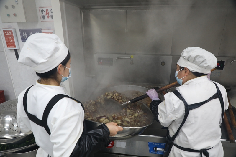 甘河街道中心校食堂工作人员正在做饭菜。刘娟摄