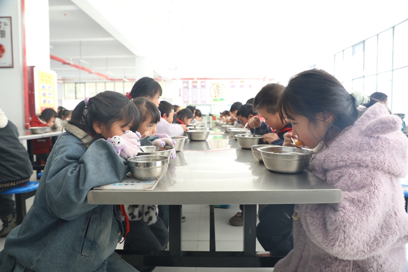 甘河街道中心校食堂里学生正在就餐。刘娟摄