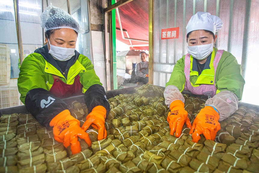 2026年1月11日，在貴州省黔西市錦繡街道金鳳社區一家食品企業，工人取出蒸熟的黃粑成品。_T9A3330