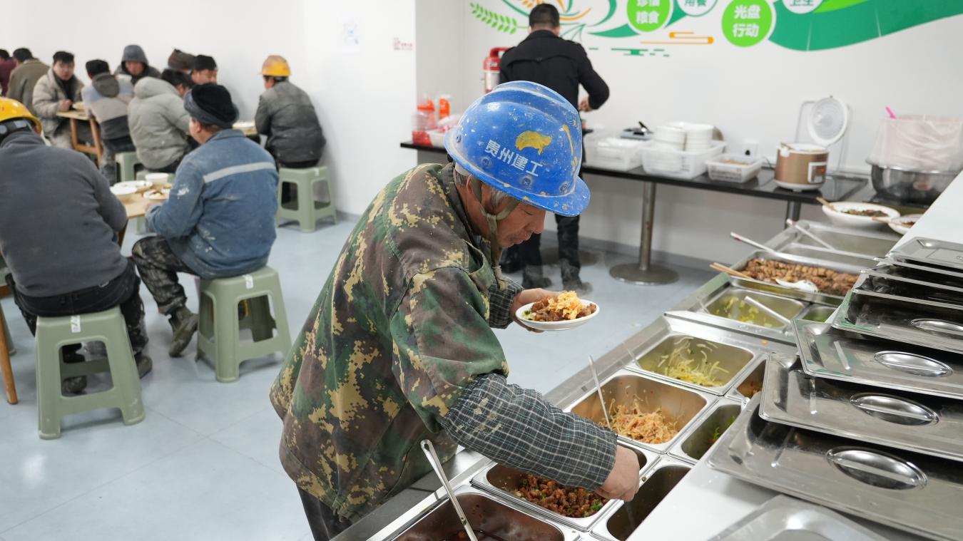 勞動者在“愛心餐飲”指定取餐點就餐。