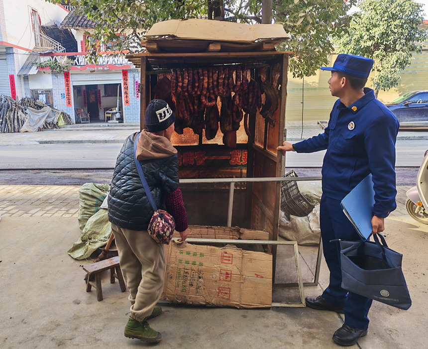 施秉县乡镇专职消防员在向群众宣传熏腊肉中的消防安全。