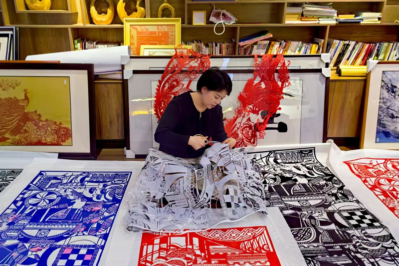 2、曹梅梅精心雕琢融合剪纸细节。习水县融媒体中心供图