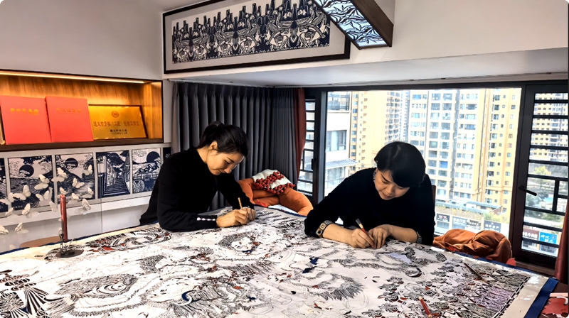 3、曹梅梅与江露莎合力制作剪纸作品。习水县融媒体中心供图