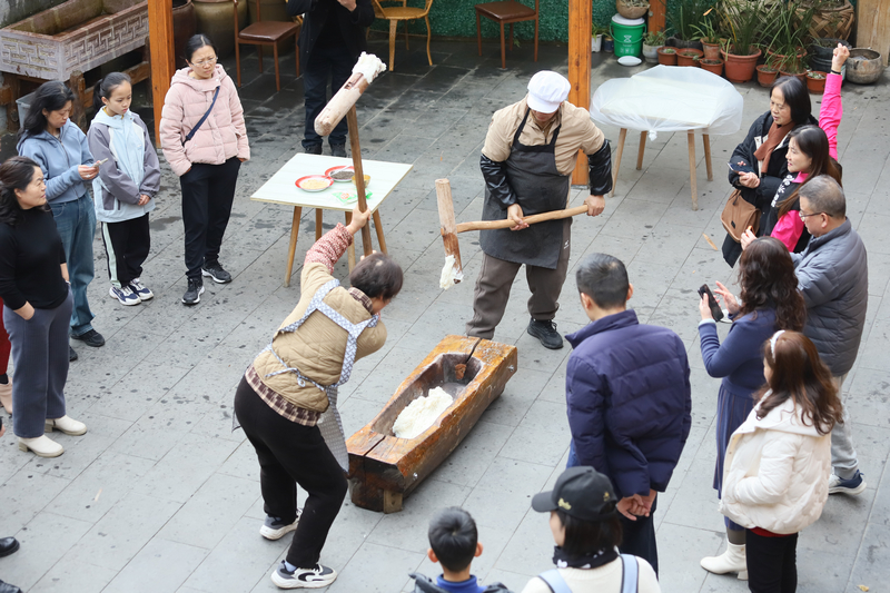 游客体验打糍粑。黎荣摄