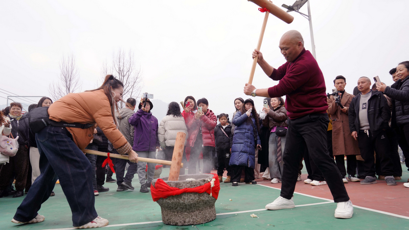 游客在体验打糍粑。