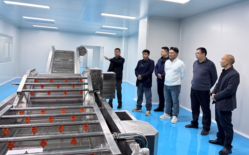 图为开业活动嘉宾们在参观精品水果加工车间