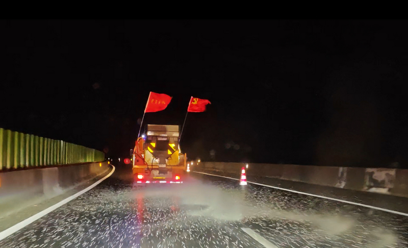 執法人員護送融雪劑車輛。