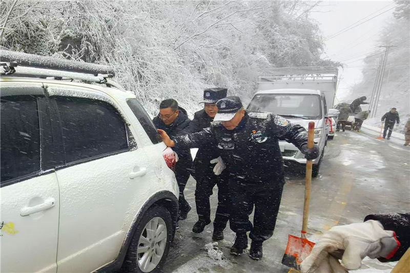 民輔警為凝凍受困車輛推車。