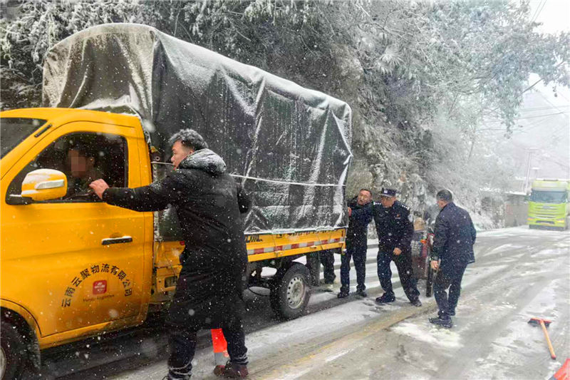 民輔警為凝凍受困車輛推車。