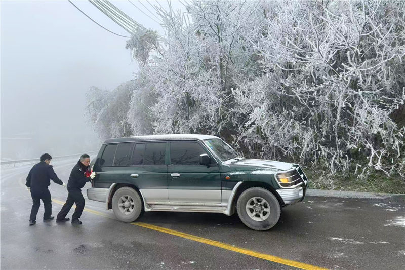 民輔警為凝凍受困車輛推車。