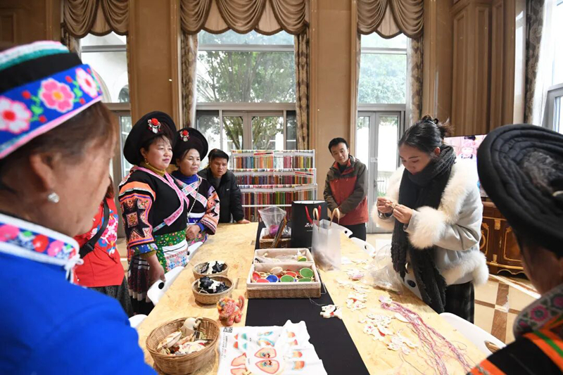 繡娘正在歐東花民族服飾博物館工作人員的指導下進行苗繡產品制作。