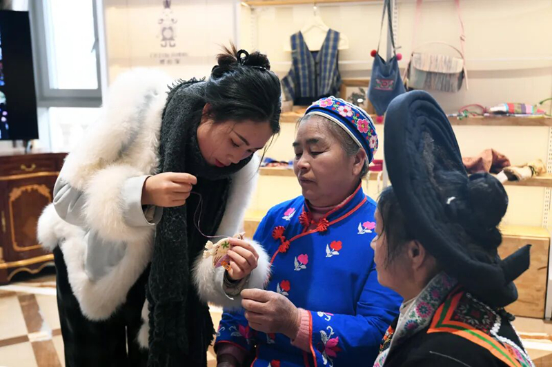 繡娘正在歐東花民族服飾博物館工作人員的指導下進行苗繡產品制作。