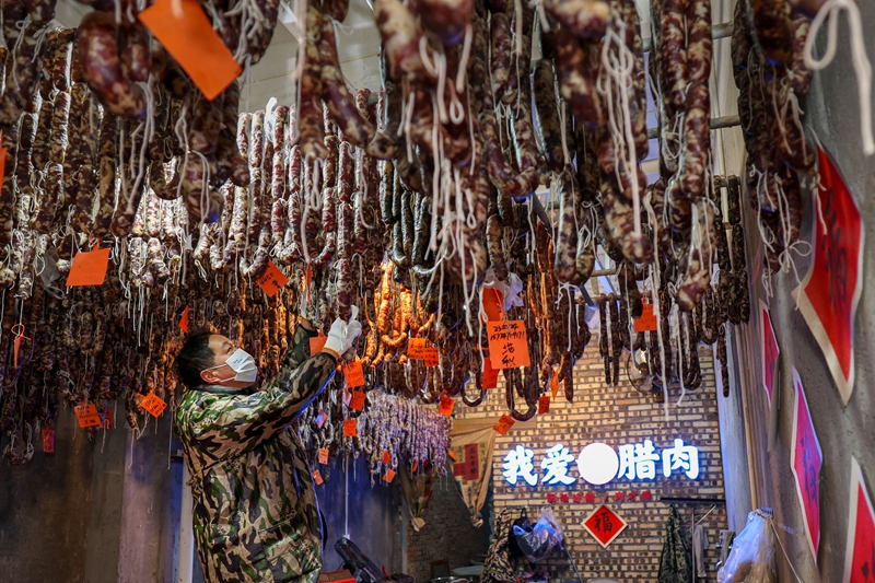 2026年1月26日，貴州省畢節市七星關區鋤禾農特產品店工人在將香腸上架。