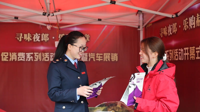 赫章縣2026年“尋味夜郎·樂購赫章”新春促消費系列活動中，國家稅務總局赫章縣稅務局深入活動同步跟進、主動靠前、精准發力開展稅收服務，圖為稅務干部向美食商戶貴州赫桃姑農產品開發有限公司參展銷售人員王藝霖了解經營情況，同時開展“點對點”答疑和“手把手”教學。（陳焰宏 攝）