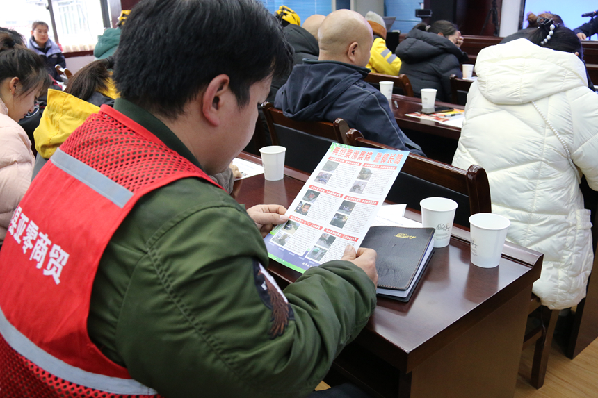 參會人員認真閱讀普法宣傳資料。