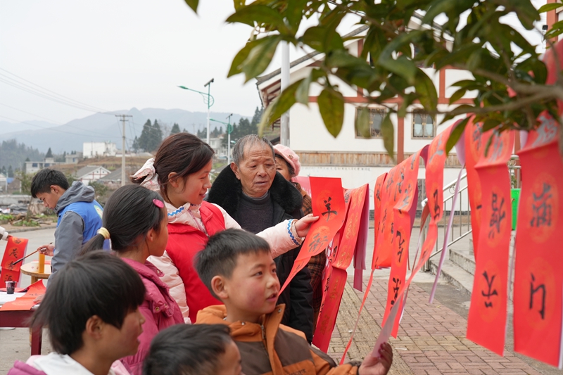 2026年1月26日，贵州省毕节市纳雍县张家湾镇普洒社区，群众在挑选大学生志愿者现场写的春联。