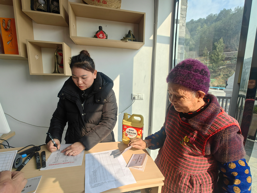 圖為石阡縣龍塘鎮困牛山村村民使用積分存折兌換生活用品。受訪單位供圖