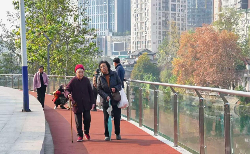 市民正在沿江步道散步。