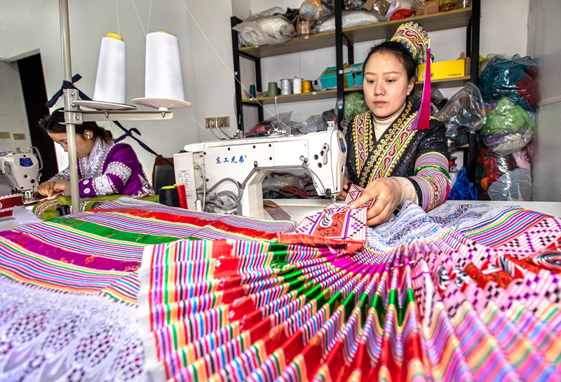 在黔西市林泉镇高锦社区一家苗族服饰加工车间，村民在制作苗族服饰。