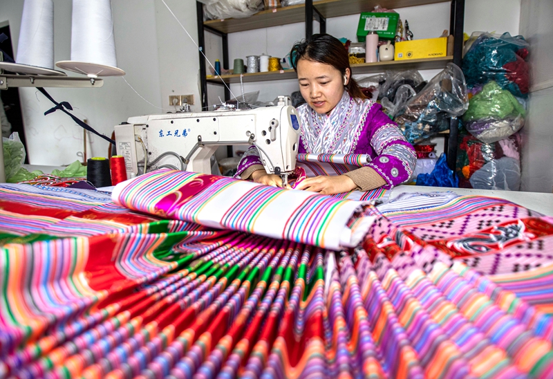 在黔西市林泉镇高锦社区一家苗族服饰加工车间，村民在制作苗族服饰。
