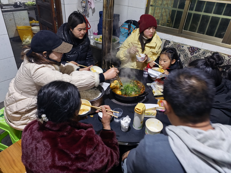 1月21日晚，被困游客在当地农户家中吃火锅。