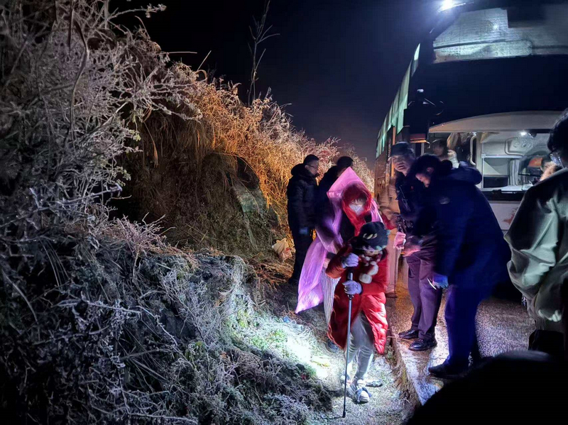 1月21日晚，救援人员组织被困游客离开凝冻路段。