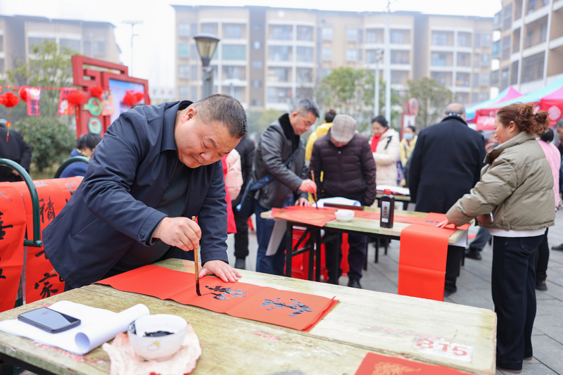 2026年1月28日，贵州省铜仁市玉屏侗族自治县平溪街道康华社区，书法志愿者给群众义务写春联。 