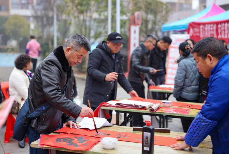 2026年1月28日，贵州省铜仁市玉屏侗族自治县平溪街道康华社区，书法志愿者给群众义务写春联。 