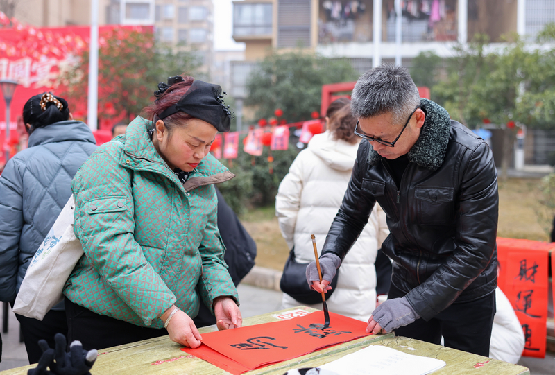 2026年1月28日，贵州省铜仁市玉屏侗族自治县平溪街道康华社区，书法志愿者给群众义务写春联。 